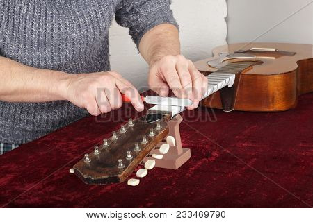 Musical Instrument Guitar Repair And Service - Worker To Sharpen The Special Tool Guitar Neck Frets.