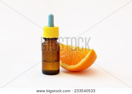 Serum With Vitamin C And A Slice Of Orange On White Background. Vitamin C Or Ascorbic Acid Is One Of