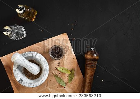 White Mortar And Pestle With Dried Peppers In Flat Lay On Black Background. Copy Space. Still Life. 