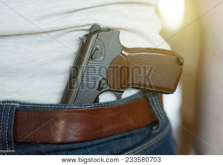 Man Wearing Gun Behind His Back. Guns Control Concept.