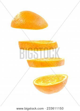 Creative Concept With Flying Orange. Sliced Orange Isolated On White Background. Levity Fruit Floati