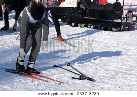 Orange Alpine Ski Boots In A Ski Mount. One Boot Is Completely Fixed On Skis, The Second Is Not