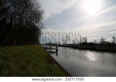 Canal Bruges-ostend In The Morning With Cyclist.