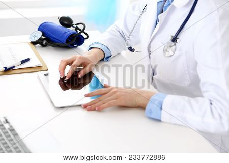 Woman Doctor Using Tablet Computer While Sitting At The Desk In Hospital Closeup. Cardiologist Check