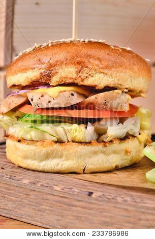 Top View Fresh Homemade Burger With Chicken, Salad, Cheese, Onion, Cucumber, Tomato, Sause And Dark 