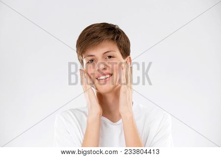 Teenage Boy With Problem Skin Applying Anti Acne Cream On Light Background