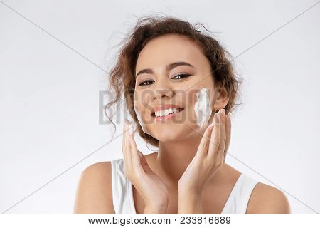 Beautiful Young Woman With Problem Skin Applying Anti Acne Cream On Light Background