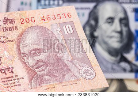 10 Indian Rupee  With Hundred Dollar Bill On Background