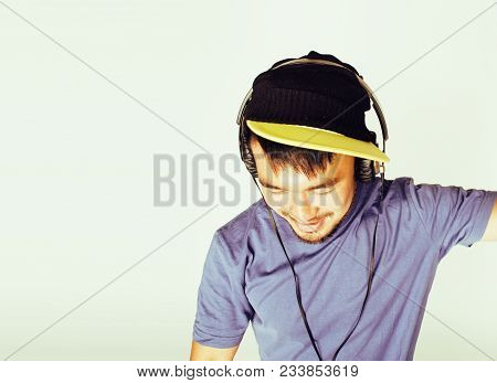 Young Asian Man In Hat And Headphones Listening Music On White Background Close Up