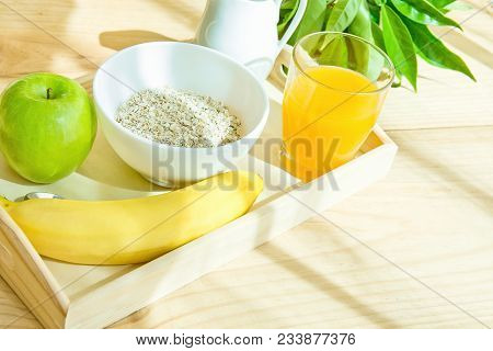 Wooden Tray With Healthy Breakfast Ingredients On Table On Terrace. Oats In Bowl Nut Milk In Pitcher