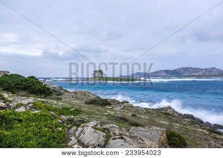 A View Of The The Torre Della Pelosa Tower And The Isola Piana Island In The Background In Stormy We