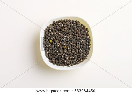 Black Gram Seed Or Udad Beans In Bowl On White Background