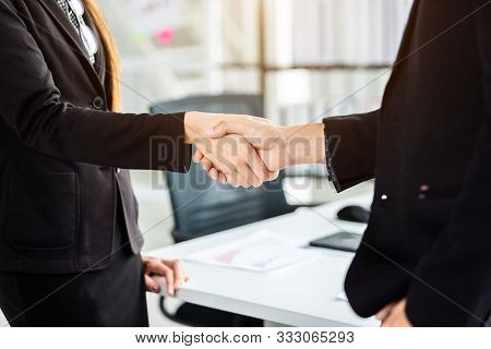 Businesswoman And Businessman Shaking Hands At In The Office Room Background After The Contract Is S