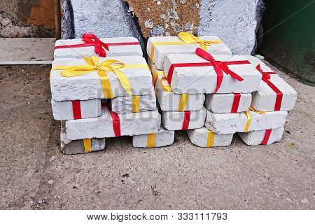 Heap Of White Bricks With Red And Yellow Ribbon As Gift To Christmas Or Birthday. Christmas Zero Was