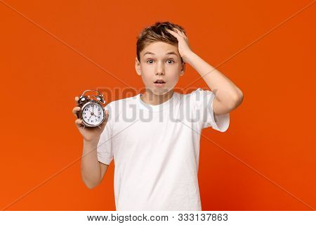 Overslept. Worried Awake Teen Boy With Alarm Clock Is Shocked Because It Is Too Late