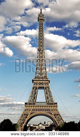 Eiffel Tower Symbol Of The City Of Paris With Hdr Effect And The White Clouds In The Blue Sky
