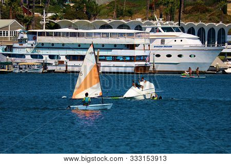 August 25, 2019 In Newport Harbor, Ca:  People Learning To Sail On Dinghy Sail Boats Including A Din