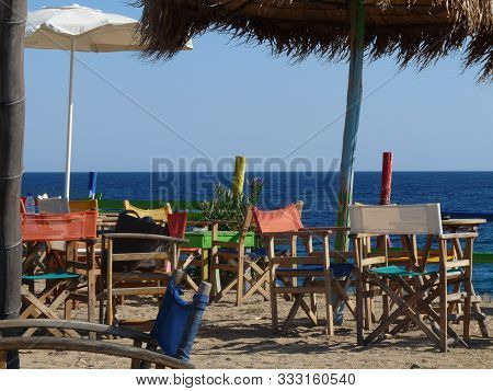 Lonely Chairs At A Beach In Greece After Season Ending