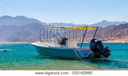 Motor Boat In The Sea Against The Coast With High Rocky Mountains In Egypt