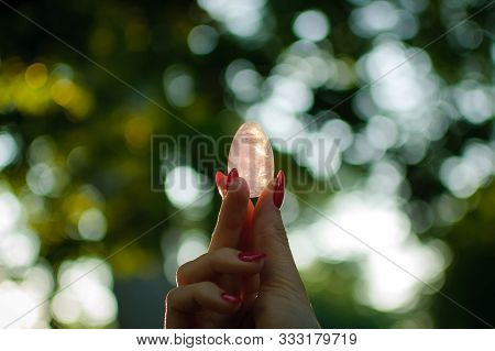 Female Hand With Transparent Amethyst Quartz Yoni Egg For Vumfit, Imbuilding Or Meditation. Shining 
