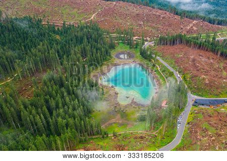 Aerial View Of Turquoise Blue Water Of Lake Carezza In Alps Dolomites. Lago Di Karersee Near Fir Tre