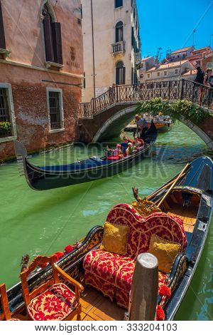Venice, Italy - August 3, 2019: Gandolier riding tourists on gondola at sunny summer day