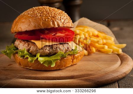 Home Made Hamburger With Beef, Onion, Tomato, Lettuce And Cheese. Fresh Burger Close Up On Wooden Ru