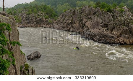 Two Men On Kayaks Paddlying On The River At Great Falls National Park, Virginia