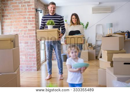 Beautiful famiily with kid moving cardboard boxes at new home