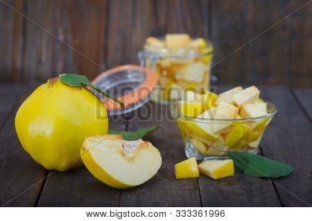 Yellow Quince Compote In A Jar And A Bowl On Wooden Background. Compote - Sweet And Healthy Fruit De