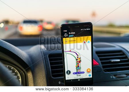 In Car Dashboard View With Smartphone Showing Waze Maps To Show The Way Thru The City In Bucharest, 