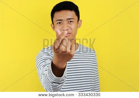 Happy Young Asiam Man Doing Finger Heart, Sign Of Love, Symbol Of Love, Isolated On Yellow Backgroun