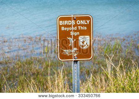 A Brown With Logo Signboard Caution Sign In Laguna Atascosa Nwr, Texas