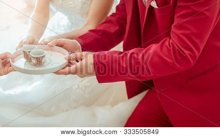 Groom And Bride In Tea Ceremony On Wedding Ceremony Day. Bride And Groom In White Wedding Dress And 