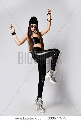 Brutal Young Woman With Long Straight Hair In Black Hat, Tight Leather Pants Leggings With Zippers, 