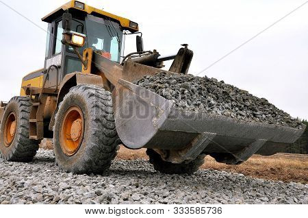 The Front-end Loader Carries Crushed Stone To Fill The Road. Special Equipment For The Repair Of The