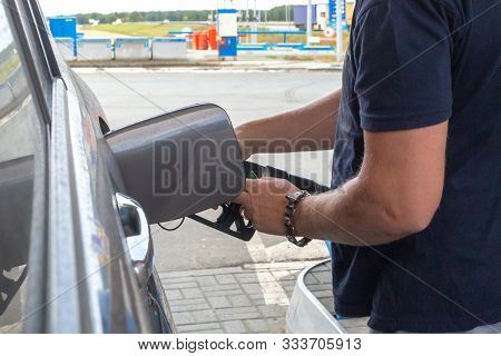 Man Inserts A Gun Into The Tank To Fill The Car