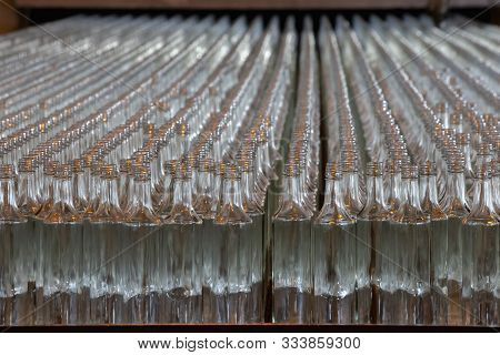 Glassworks. Glass Industry. Many Glass Bottles On A Factory Conveyor In A Row