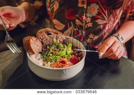 Woman Eating Organic Food. Fresh Seafood Recipe. Fresh Salmon Poke Bowl With Rice, Egg, Bread, Fresh