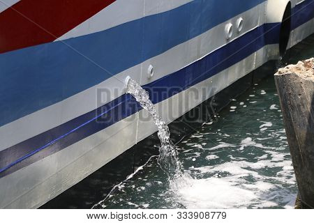 Water That Was Pumped Out Of The Boat While Parked At The Pier. Water That Was Taken Out Of The Ship