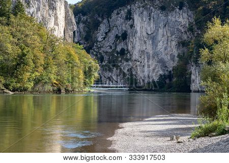 Passenger Ship Passing Danube Breakthrough Near Kelheim, Bavaria, Germany In Autumn With Gravel Bank
