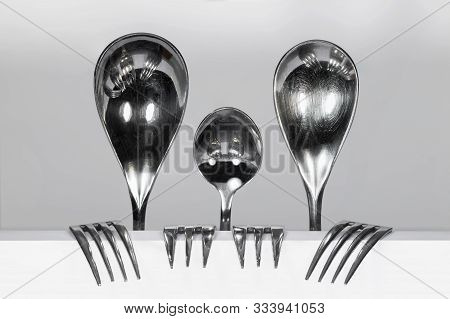 Cuterly Family Of Three Metal Spoons And Four Forks Against A White Background
