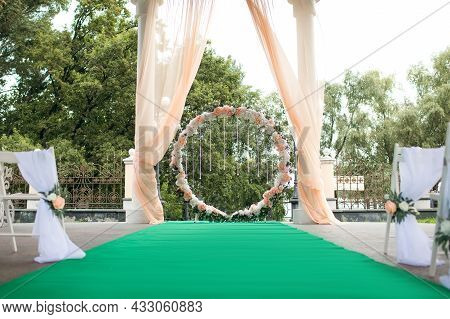 Round Wedding Arch For Wedding Ceremony With Flowers And Crystal Pendants With Green Carpet For Brid