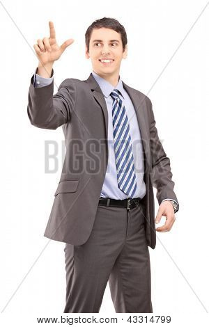 นักธุรกิจหนุ่มในชุดสูทที่สัมผัสสิ่ง imaginery แยกต่างหากบนพื้นหลังสีขาว