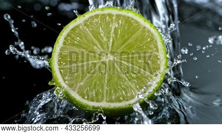 Freeze Motion Shot of Fresh Lime with Water Splash, close-up.