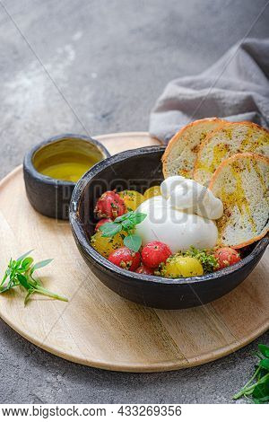 Buratta Cheese With Cherry Tomatoes, Basil And Olive Oil On Black Plate With Crusty Bread. Copy Spac