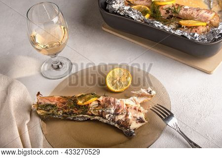 Fish Congrio Baked In Foil, Next To The Plate Is One Ready-made Fish With Lemons And Dill. There Is 