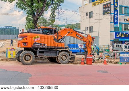 Doosan Backhoe Digging Up Street In Sintanjin Dong.