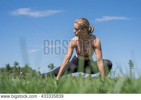 Sportive Woman Working Out In The Park In Sunny Summer Day