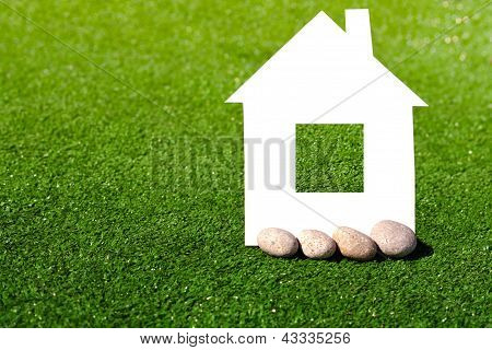 Yeşil çim karşı taşlarla karton Evi